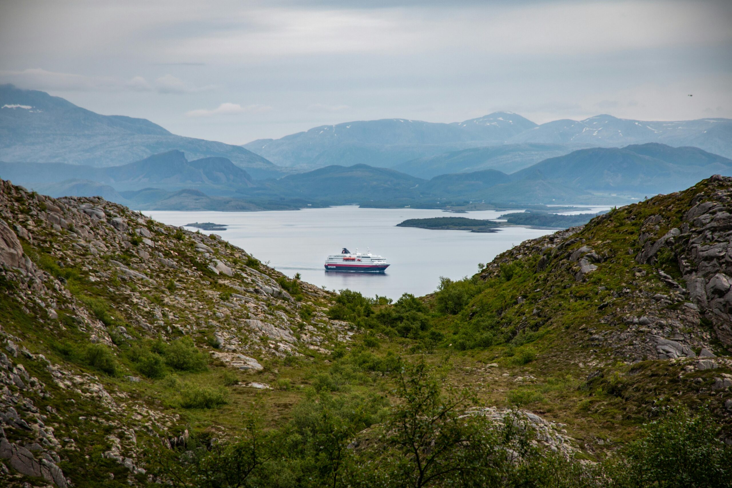 Beautiful view of a cruise ship in a fjord surrounded by mountains in Nordland, Norway.