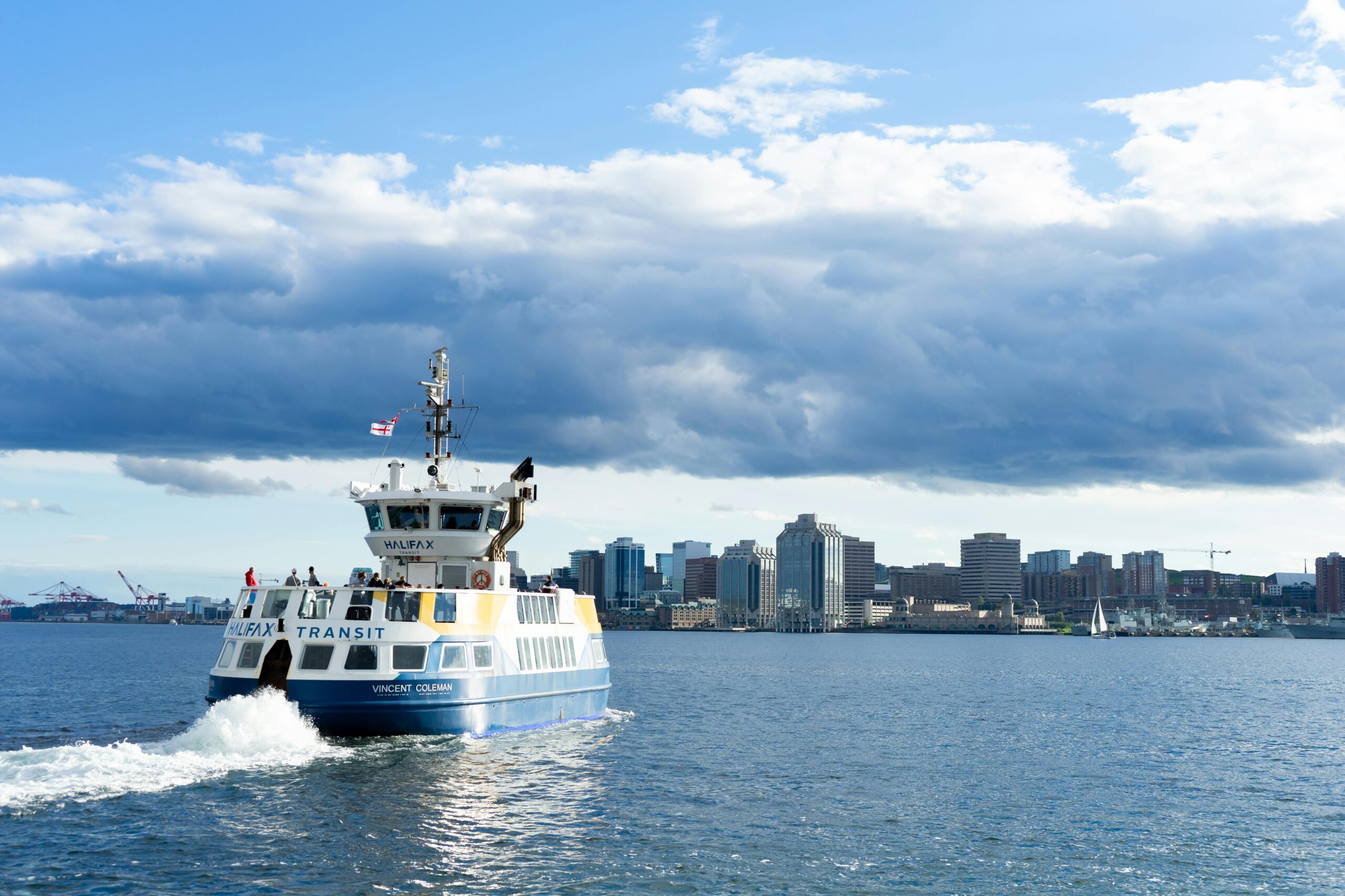 Halifax Transit ferry crossing the harbour with the downtown skyline in the background on a clear day.